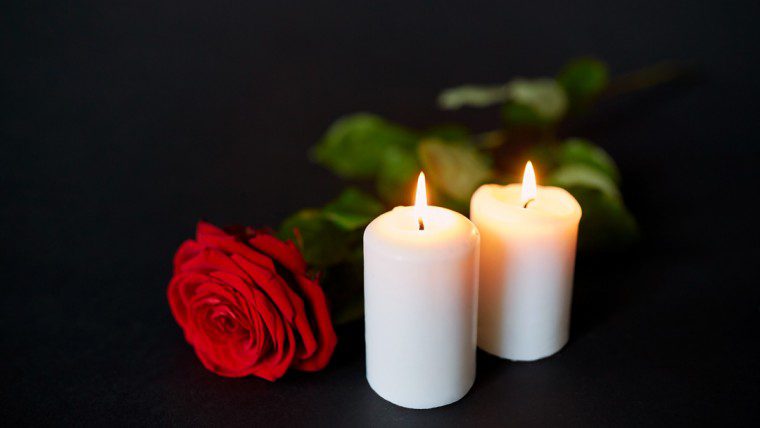 Trauerfall - Kerzen neben einer Rose
